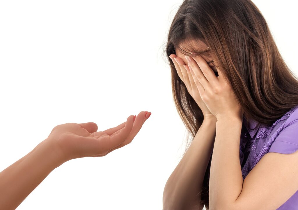 Main tendue vers une femme en détresse, représentant l’aide, le soutien et la relation à l’autre.