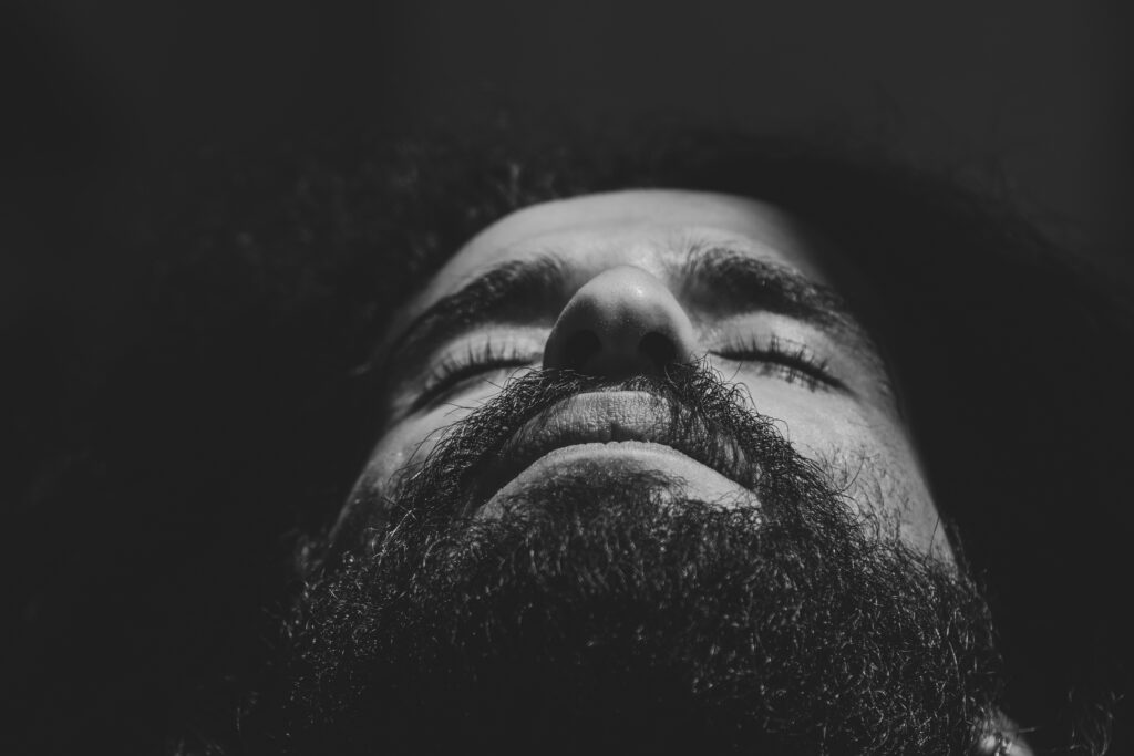 Portrait en noir et blanc d’un homme les yeux fermés, illustrant la profondeur intérieure, le retrait émotionnel et le besoin de retrouver son équilibre.
