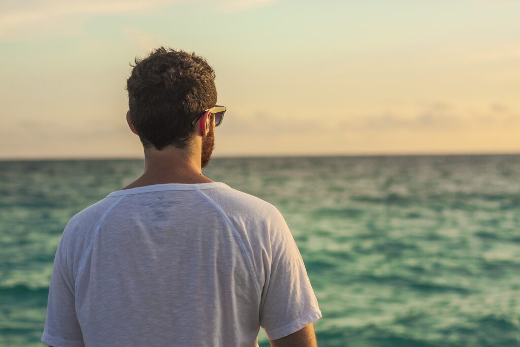 Homme regardant la mer, illustrant une période de bilan et d’introspection pendant le mois universel 9 d’août 2026.